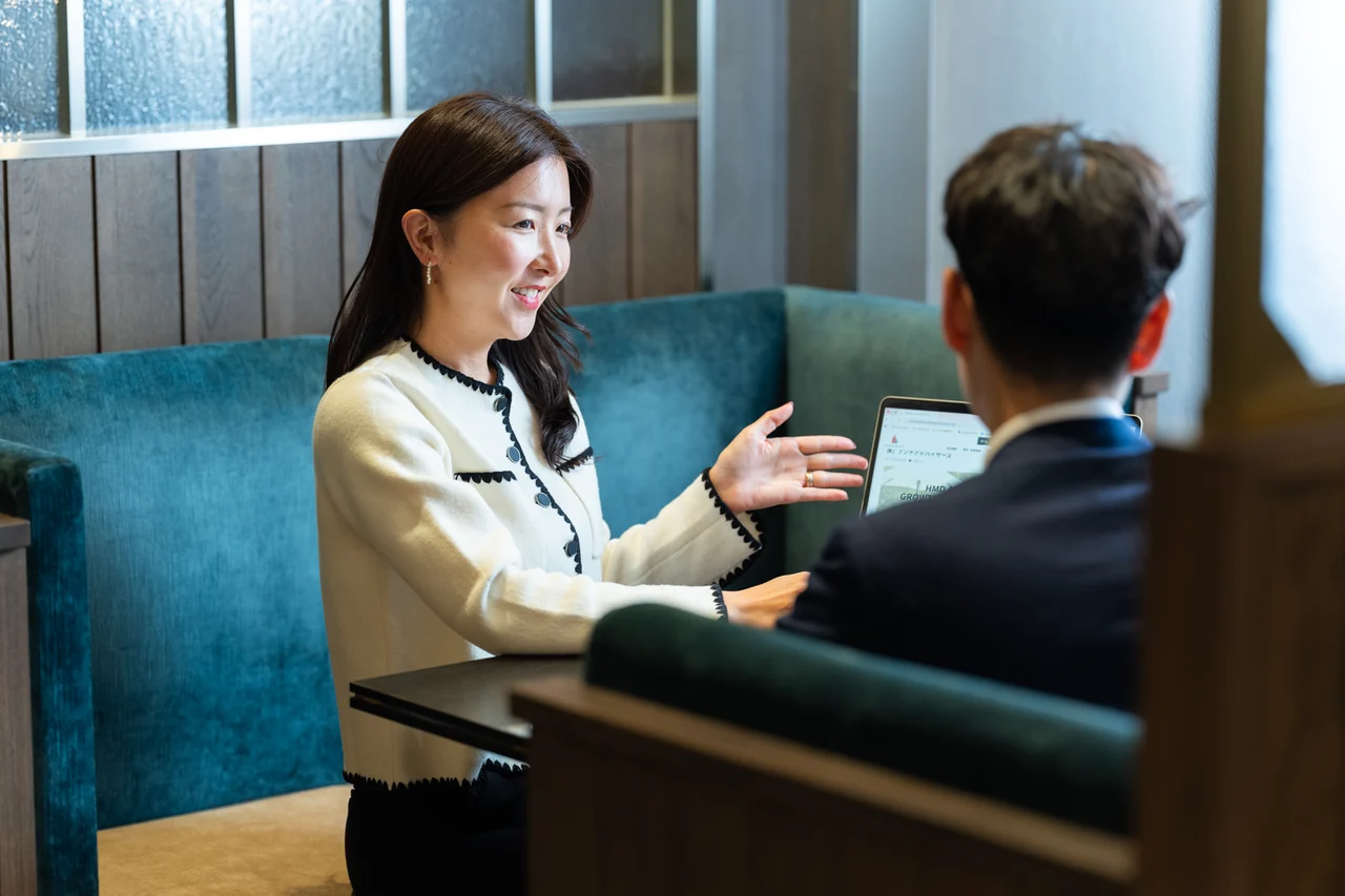 笑顔で資料を説明するアンナ社長